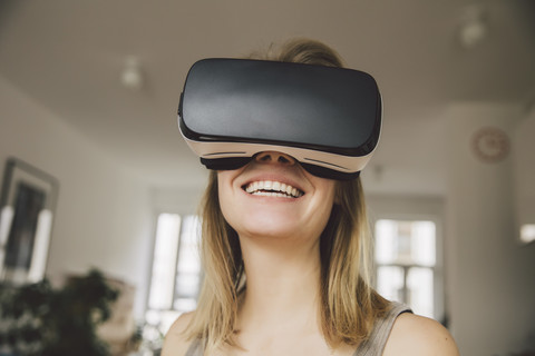 Laughing woman wearing virtual reality glasses stock photo