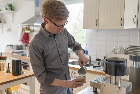 Cappuccino, Mann gießt Milchschaum in Kaffeetasse - PAF001567