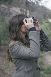 Frau beim Fotografieren mit einer analogen Kamera - ABZF000231