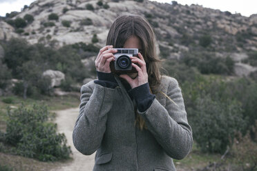 Frau beim Fotografieren mit einer analogen Kamera - ABZF000234