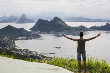 Brasilien, Rio de Janeiro, Tourist steht am Aussichtspunkt und hebt die Arme - MAUF000252