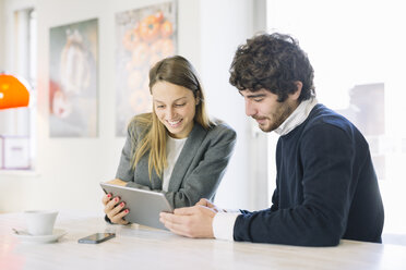 Zwei Kollegen in einem Café mit Blick auf ein digitales Tablet - ALBF000029