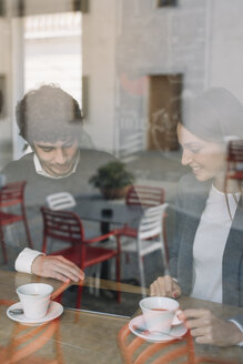 Zwei Kollegen in einem Café mit Blick auf ein digitales Tablet - ALBF000031