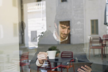 Young man in a cafe looking at digital tablet - ALBF000033