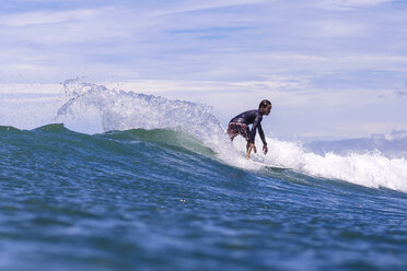 Indonesien, Lombok, Surfer auf einer Welle - KNTF000243