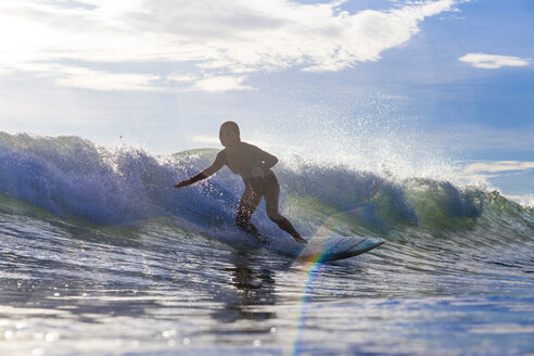 Indonesien, Lombok, Surfer auf einer Welle - KNTF000245
