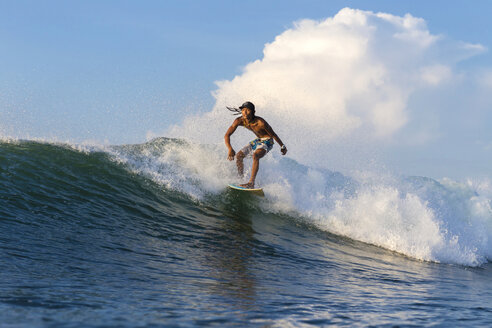 Indonesien, Lombok, Surfer auf einer Welle - KNTF000248