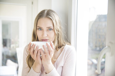 Portrait of blond woman with bowl of coffee - FMKF002441