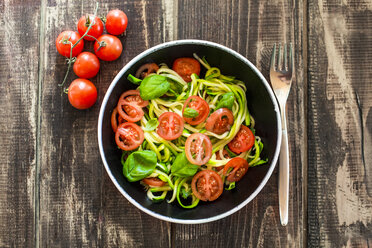 Zoodles, zucchini spaghetti, with tomato and basil in bowl - SARF002614