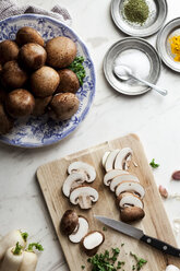 Sliced portobello mushrooms, parsley and kitchen knife on wooden board - VABF000281