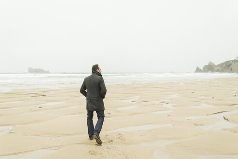 France, Bretagne, Finistere, Crozon peninsula, man walking on the beach - UUF006646