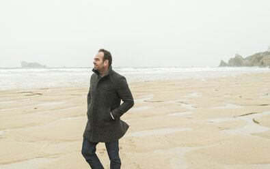 France, Bretagne, Finistere, Crozon peninsula, man walking on the beach - UUF006647