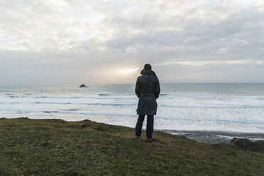 France, Bretagne, Finistere, Crozon peninsula, woman standing at the coast - UUF006656