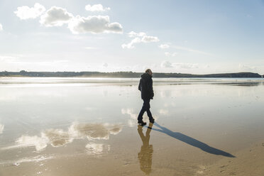 France, Bretagne, Finistere, Crozon peninsula, man walking on the beach - UUF006663