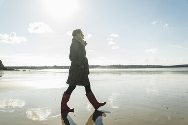 France, Bretagne, Finistere, Crozon peninsula, woman walking on the beach - UUF006666