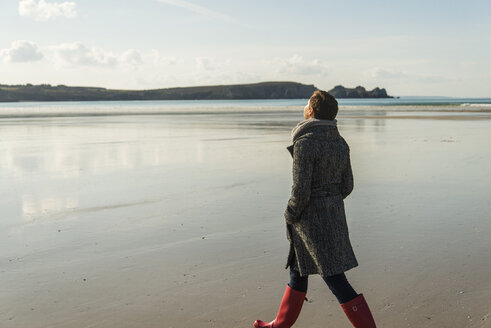 France, Bretagne, Finistere, Crozon peninsula, woman walking on the beach - UUF006667