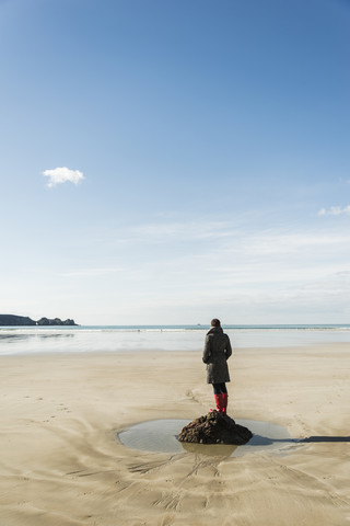 Frankreich, Bretagne, Finistere, Halbinsel Crozon, Frau steht am Strand, lizenzfreies Stockfoto