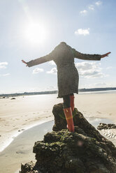 France, Bretagne, Finistere, Crozon peninsula, woman balancing on rock on the beach - UUF006676