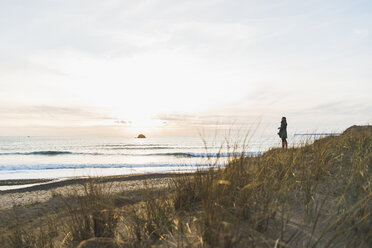 France, Bretagne, Finistere, Crozon peninsula, woman standing at the coast - UUF006682