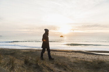 Frankreich, Bretagne, Finistere, Halbinsel Crozon, Mann beim Spaziergang an der Küste bei Sonnenuntergang - UUF006691