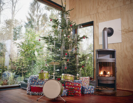 Weihnachtsgeschenke unter dem Weihnachtsbaum neben dem gemütlichen Kamin - RHF001297