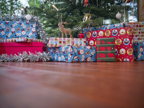 In buntes Geschenkpapier eingewickelte Weihnachtsgeschenke unter dem Weihnachtsbaum, lizenzfreies Stockfoto