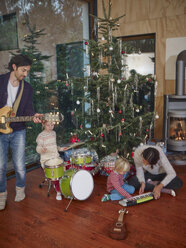 Gemeinsam musizierende Familie unter dem Weihnachtsbaum - RHF001339