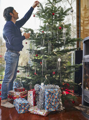 Man decorating Christmas tree - RHF001355