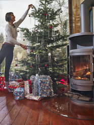 Frau beim Schmücken des Weihnachtsbaums - RHF001357