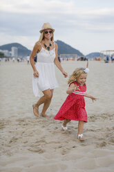 Brasilien, Rio de Janeiro, glückliche Mutter und Tochter laufen am Strand der Copacabana - MAUF000261