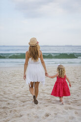 Brasil, Rio de Janeiro, mother and daughter walking on Copacabana beach - MAUF000263