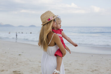 Brasil, Rio de Janeiro, mother carrying daughter on Copacabana beach - MAUF000265