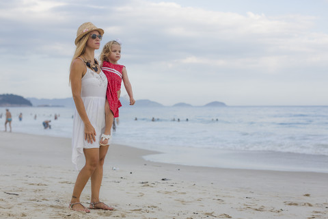 Brasilien, Rio de Janeiro, Mutter trägt Tochter am Strand der Copacabana, lizenzfreies Stockfoto