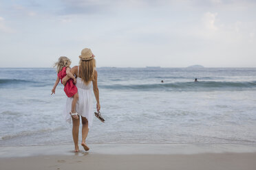 Brasilien, Rio de Janeiro, Mutter trägt Tochter am Strand der Copacabana - MAUF000267