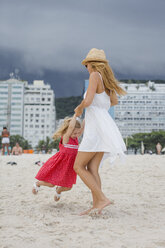 Brasilien, Rio de Janeiro, Mutter und Tochter spielen am Strand der Copacabana - MAUF000270