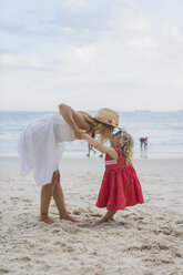 Brasilien, Rio de Janeiro, Mutter küsst Tochter am Strand der Copacabana - MAUF000272