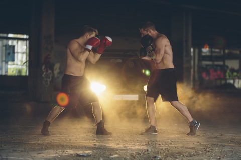 Zwei Boxer kämpfen in einer verlassenen Fabrik, lizenzfreies Stockfoto