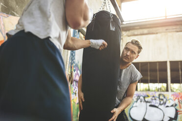 Boxer exercising at punch bag - MADF000842