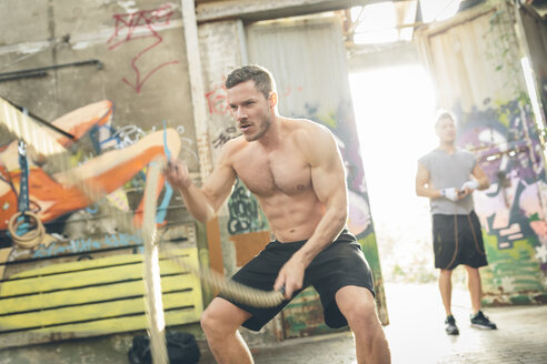 Junger Mann beim Training mit Seilen - MADF000845