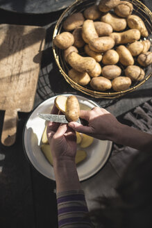 Frauenhände schneiden rohe Kartoffeln - DEGF000681
