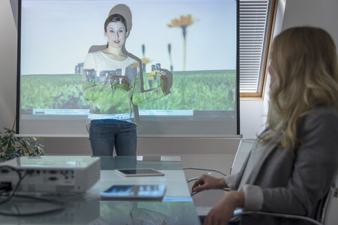 Frau führt eine Präsentation mit Projektor in einem Konferenzraum durch - PAF001584