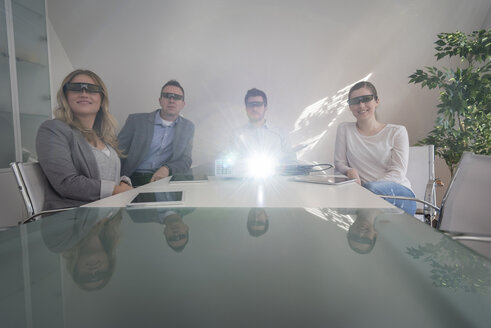 Vier Kollegen mit 3D-Brillen bei einer Präsentation mit Projektor im Konferenzraum - PAF001587