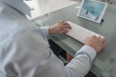Mann benutzt Tastatur für digitales Tablet im Büro - PAF001592