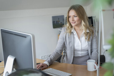 Young woman at desk in office - PAF001622