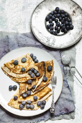 Crepes mit Blaubeeren mit Puderzucker bestreut auf einem Teller - SBDF002696