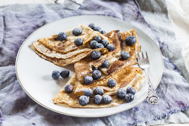 Crepes with blueberries sprinkled with icing sugar on plate - SBDF002697