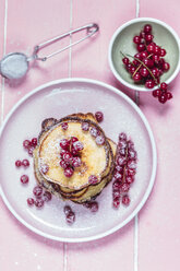 Stack of American pancakes with red currents sprinkled with icing sugar - SBDF002704