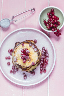 Stapel amerikanischer Pfannkuchen mit roten Johannisbeeren, bestreut mit Puderzucker - SBDF002704