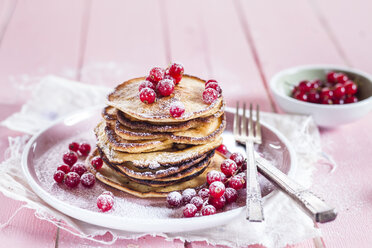 Stack of American pancakes with red currents sprinkled with icing sugar - SBDF002706