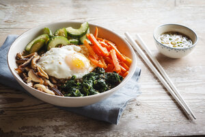 Vegetarian korean rice bowl with mushroom, spinach, cucumber, carrot and fried egg - EVGF002835